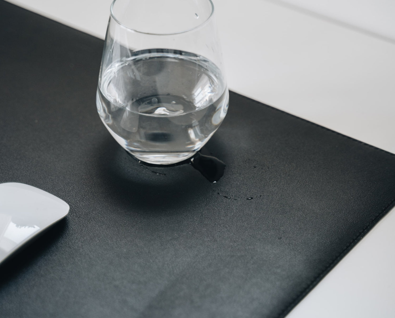 Glass with a drink on ULX desk mat